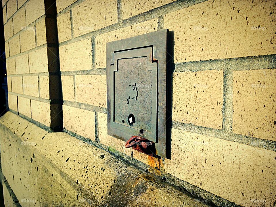 Water access panel on a brick wall