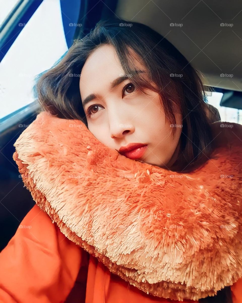 Close-up view of young woman sitting facing window in car