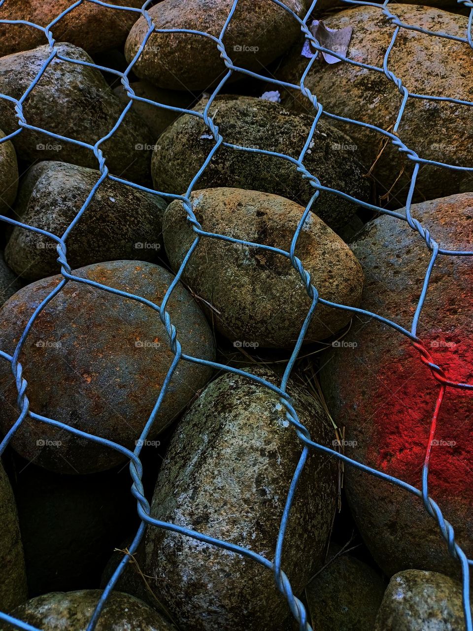 Rocks behind wire fence. round stones
laid in gabion. Background or texture. Stone wall
The photo shows a
wall that is
constructed of river stones.