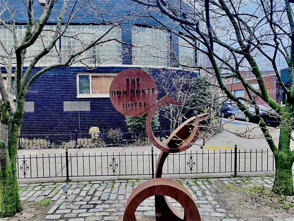 To advertise its presence here in “Greenpoint”, Bklyn at “Newtown Creek” by the “Pulaski Bridge” the already well known “BOXHOUSE Hotel” has added a modern art inspired wooden sculpture sign in front of the building. 2023. Hypnotic Productions