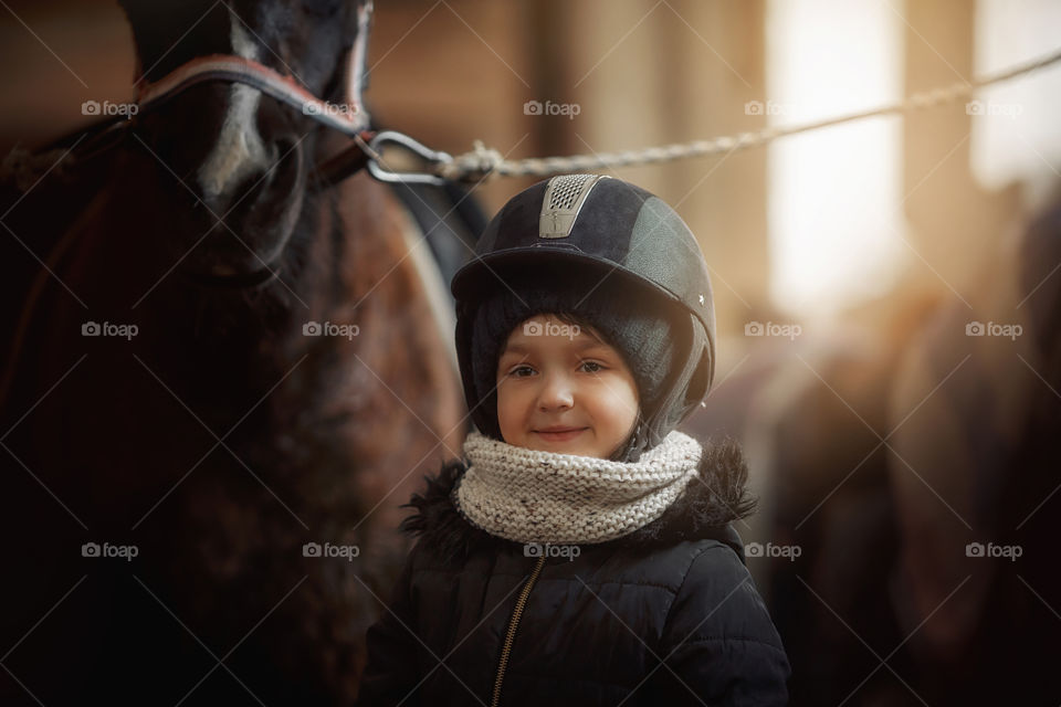 Girl in horse riding wear in a stable