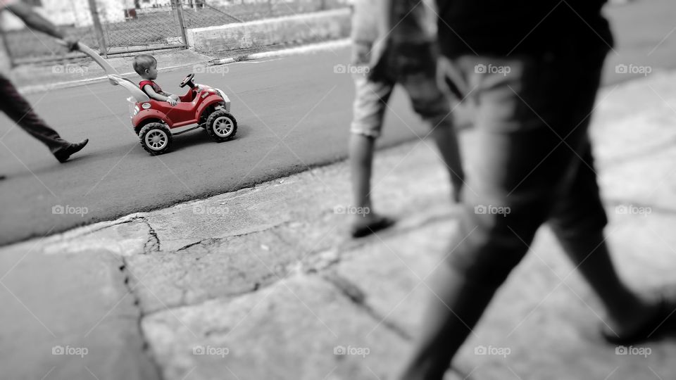 Criança em carrinho na rua.