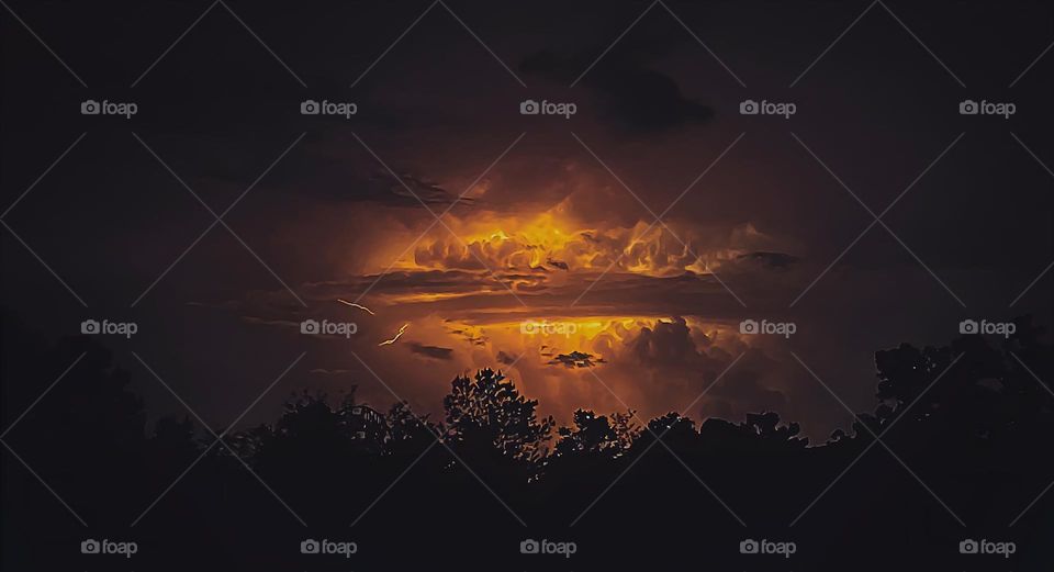 High and low storm clouds with active lightning activity.