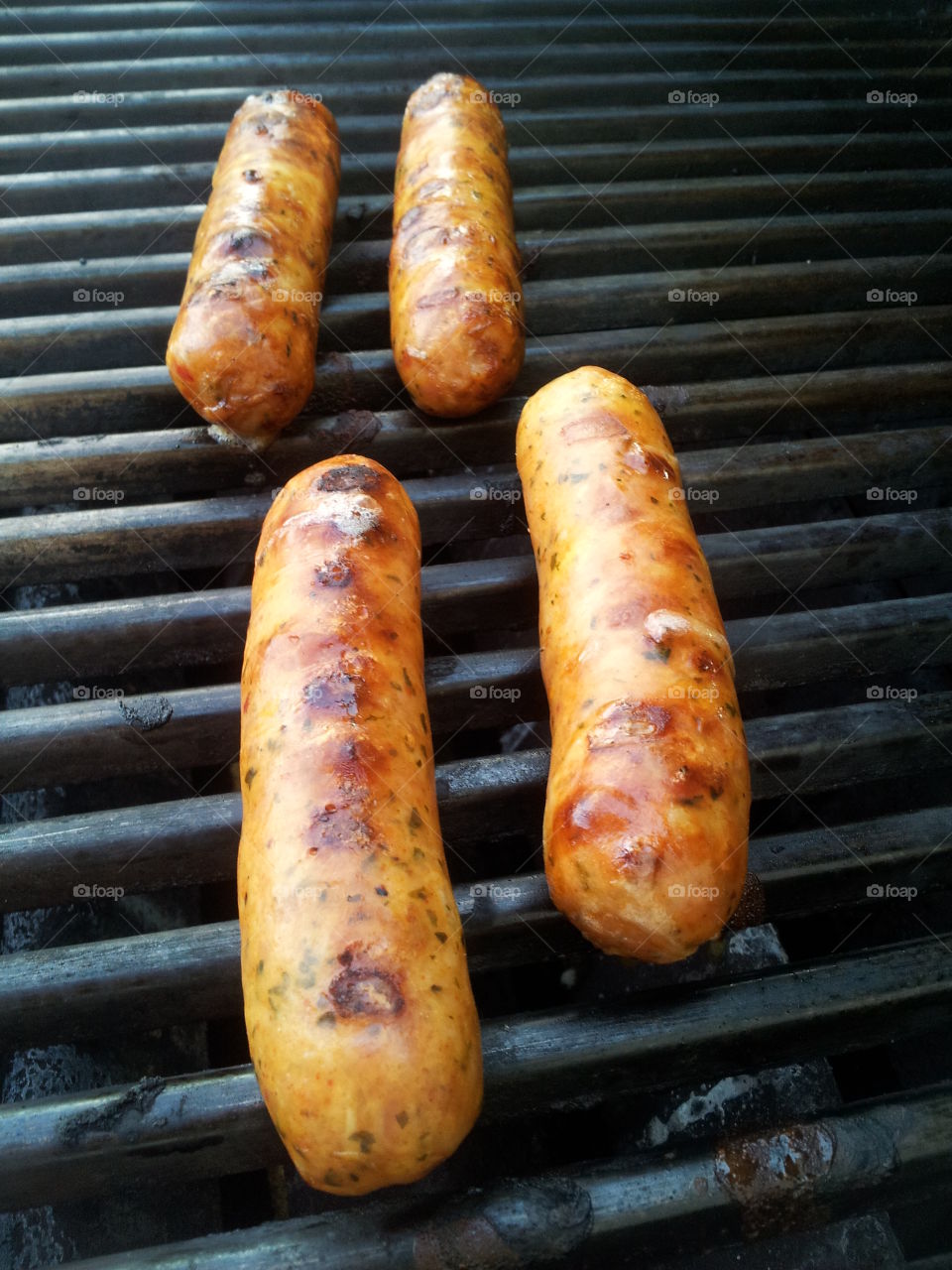 Brats cooking on the grill