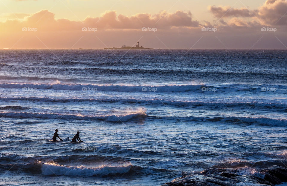 Two people paddle boarding in a sea