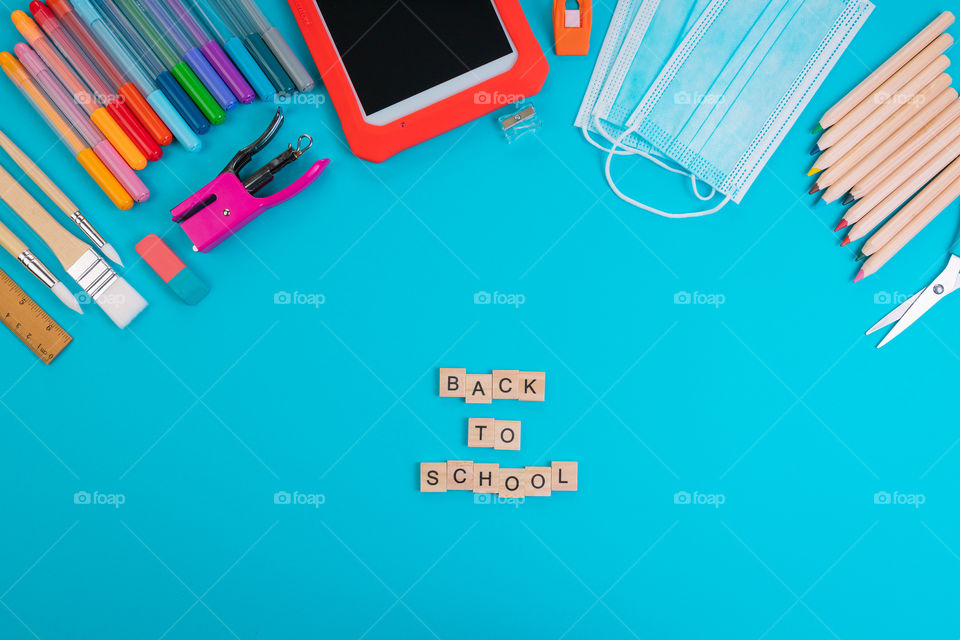 Set of school items with “Back to school” lettering on a blue background. Back to school concept. Top view. Copy space