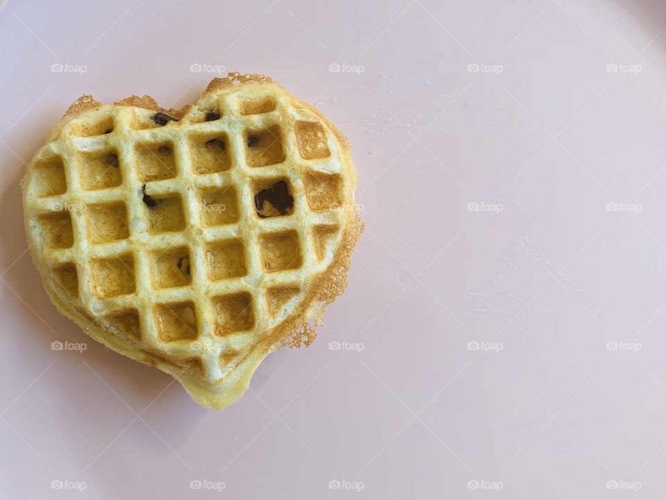 Heart shaped waffles for breakfast on a pink plate 