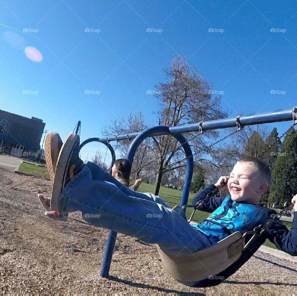 boy swinging and laughing