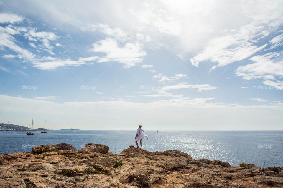 The girl is staying on the rock