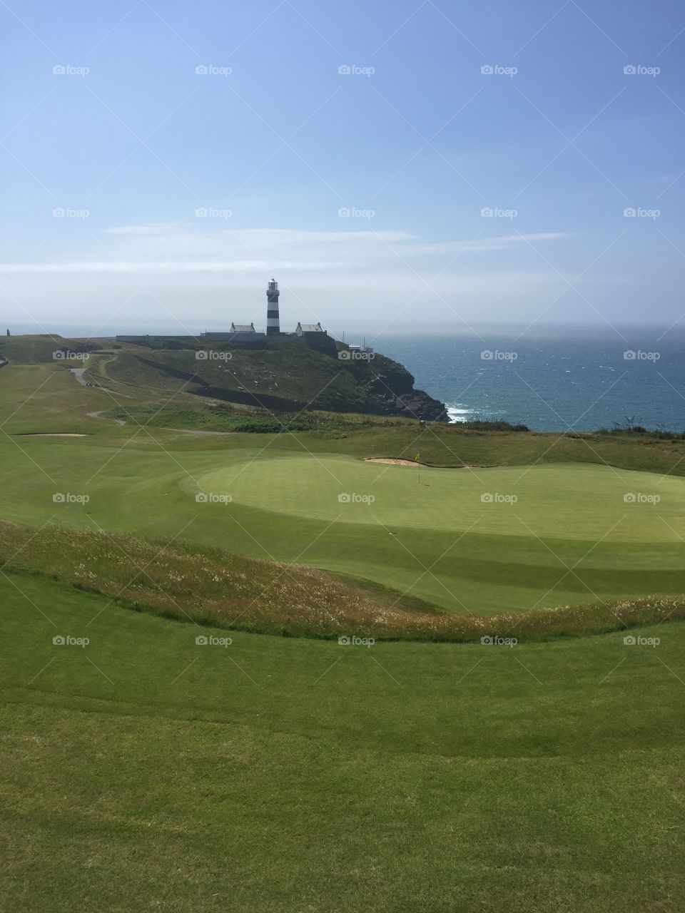 Old Head golf club in Ireland. Lighthouse in the background. Beautiful green fairways and greens. 