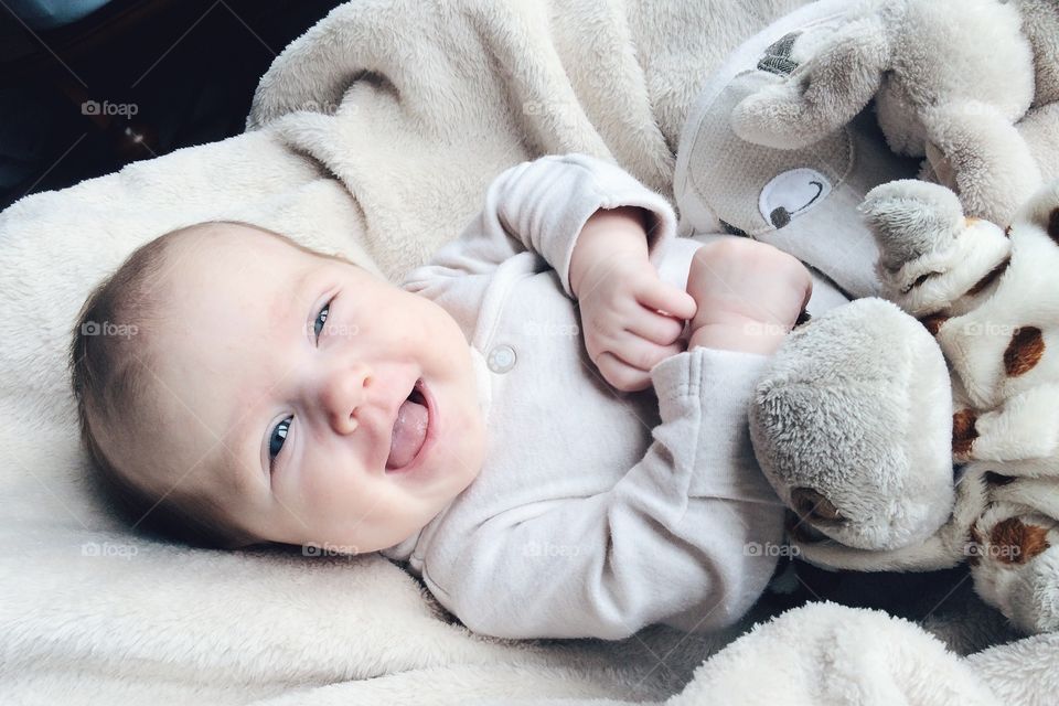 Happy baby boy lying on bed