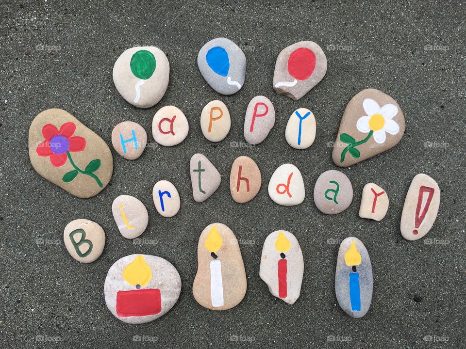 Happy Birthday message on black sand 