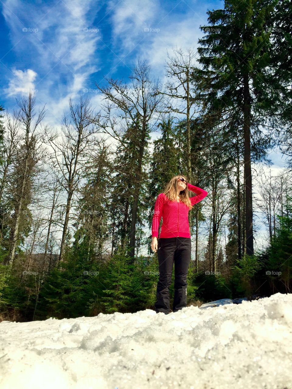 Young woman in sports clothes hiking in the forest in spring