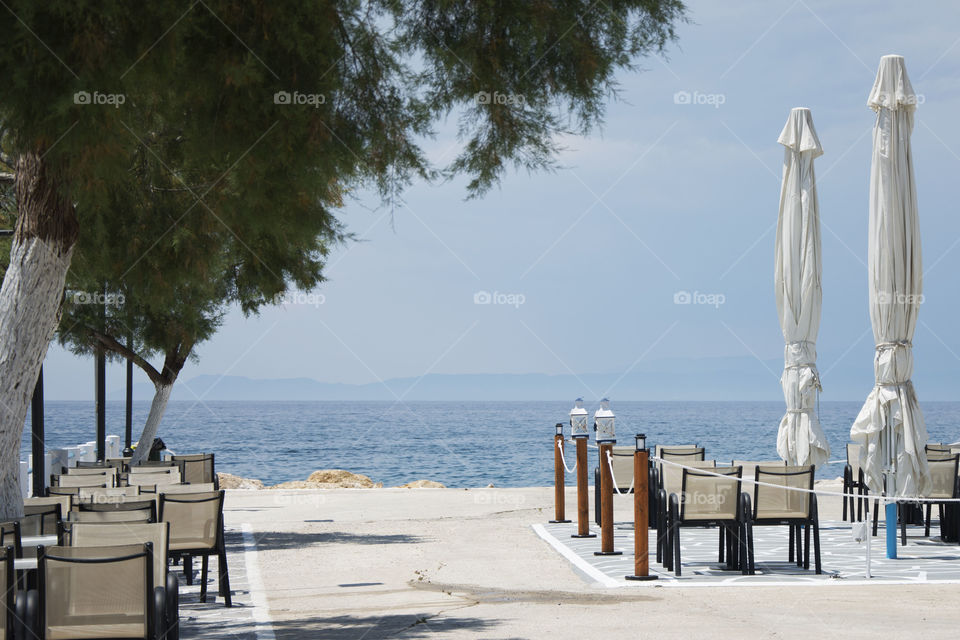 tables and chairs on coast. tables and chairs at seaside with beautiful view towards sea horizon