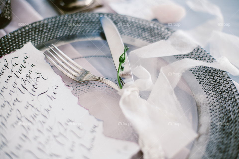 Graphic arts of beautiful wedding calligraphy cards and silver plate with cutlery on festive wedding table. 