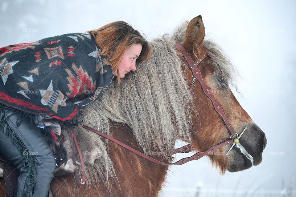 Young woman hugging her horse