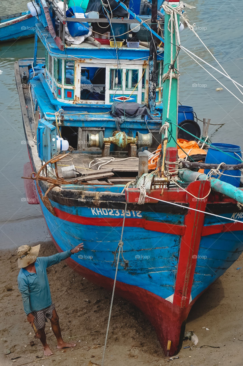 Vietnamese fisherman and vibrant vessel in Nha Trang 