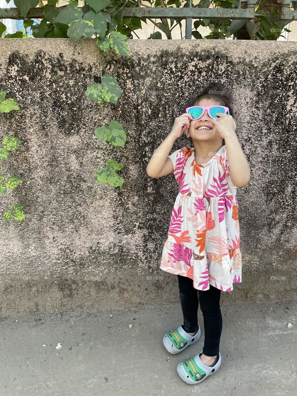 Little girl tries on sunglasses, looking at the sun with sunglasses on, toddler girl with sunglasses on, toddler girl on vacation, toddler girl being adorable 