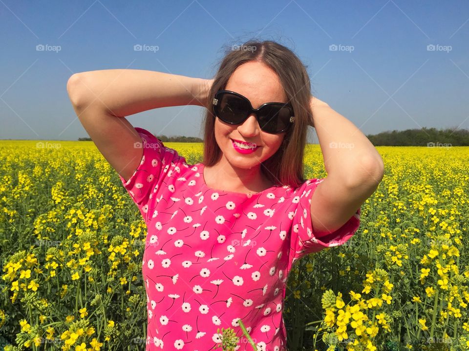 Girl in sunglasses standing at flower field