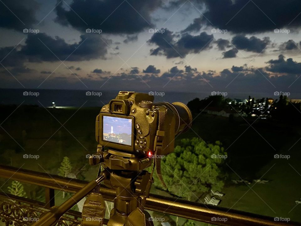 Camera and taking photo of sunset 