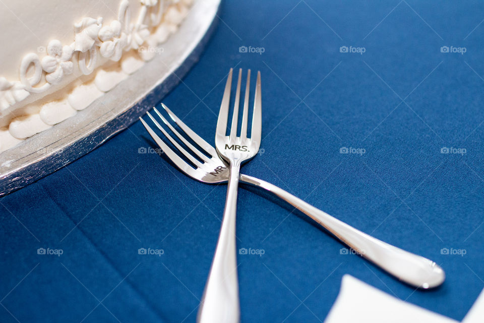 Two forkes crossing g on blue table