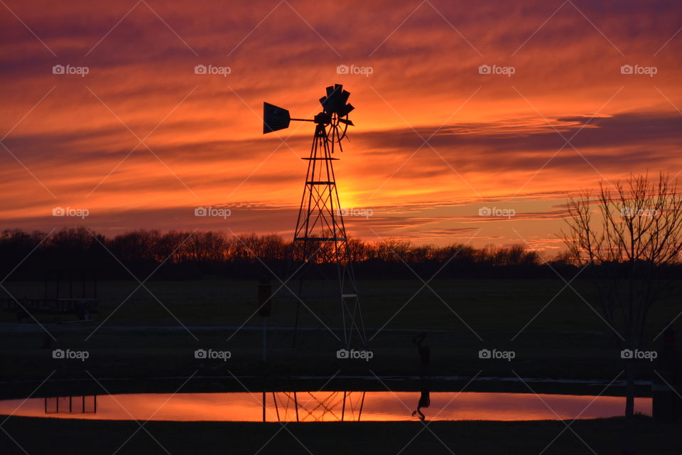 Silhouette of an old wind will at sunset