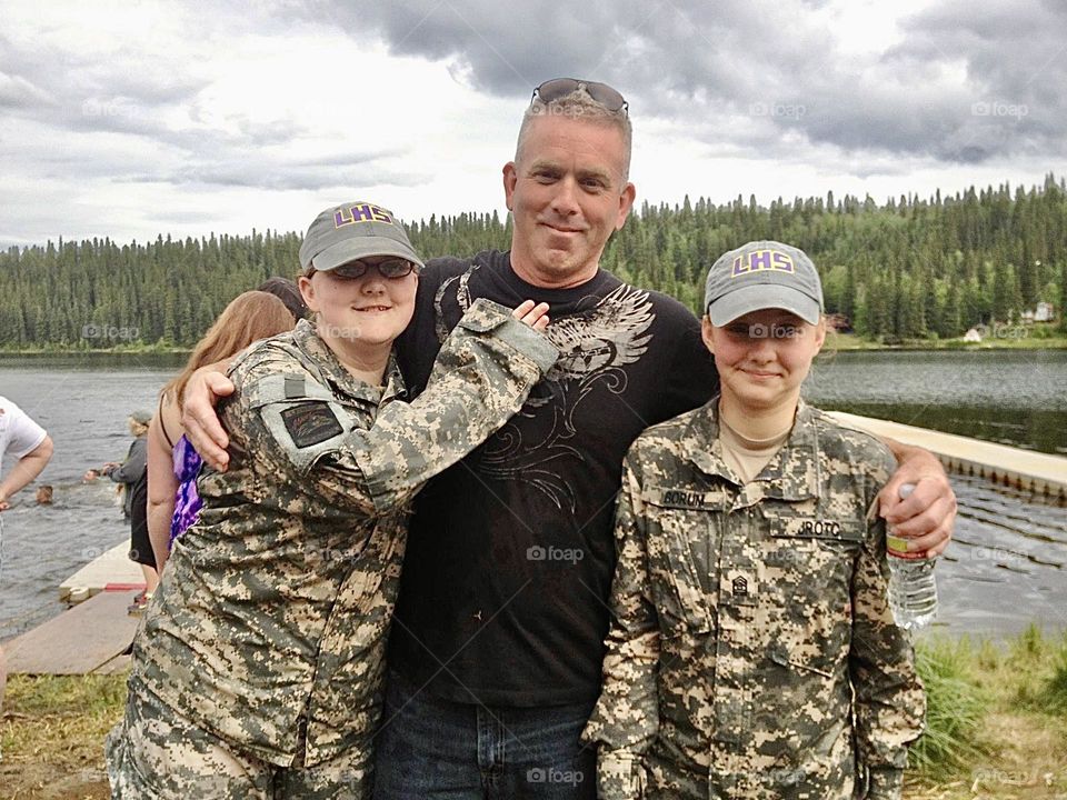 Gleaming with Pride.  Just a fun, loving Dad with his Daughters at a JROTC event, enjoying life. 