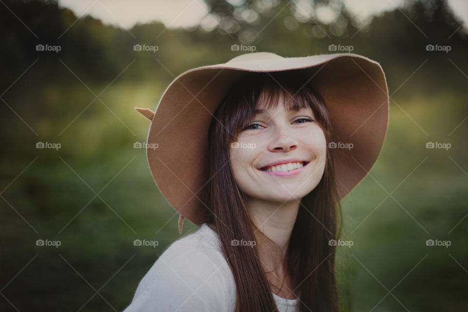 Portrait of Young woman in hat at evening park 