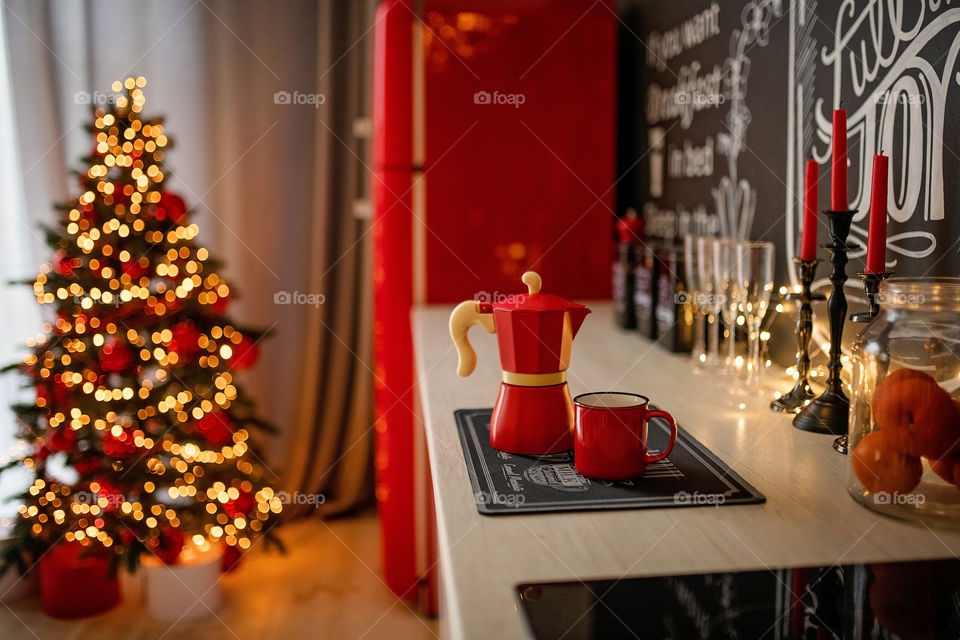 Festive winter cozy kitchen interior with garlands, decorations and gifts.  Christmas dinner at the decorated table.