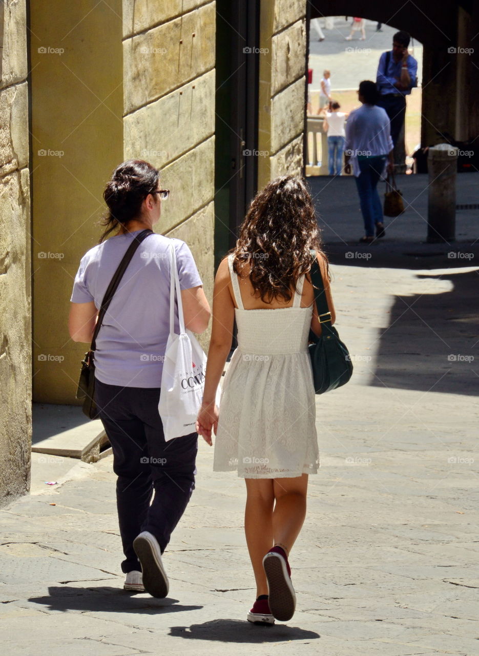 two girlfriends are walking in the street