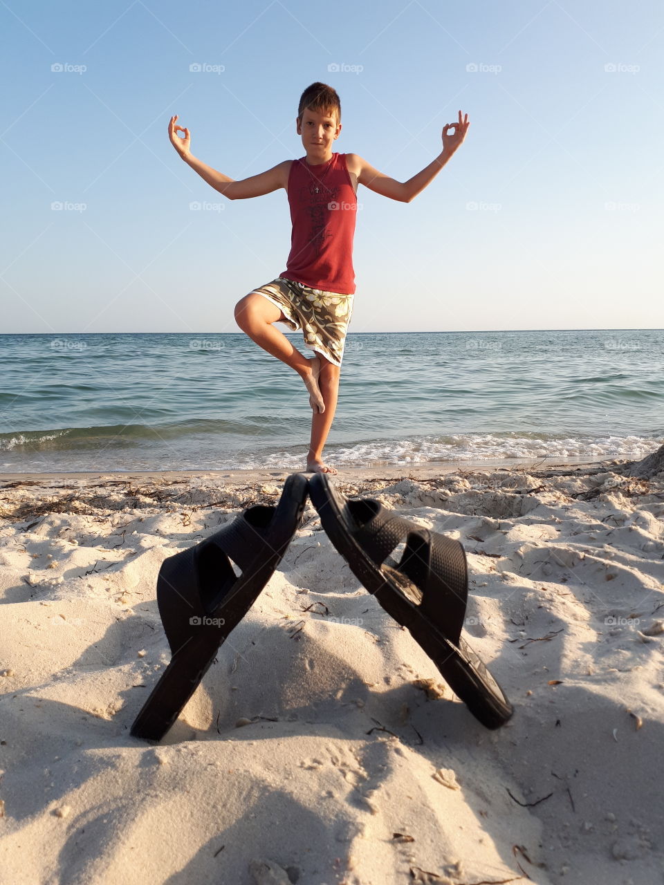 Teenager doing yoga at the beach