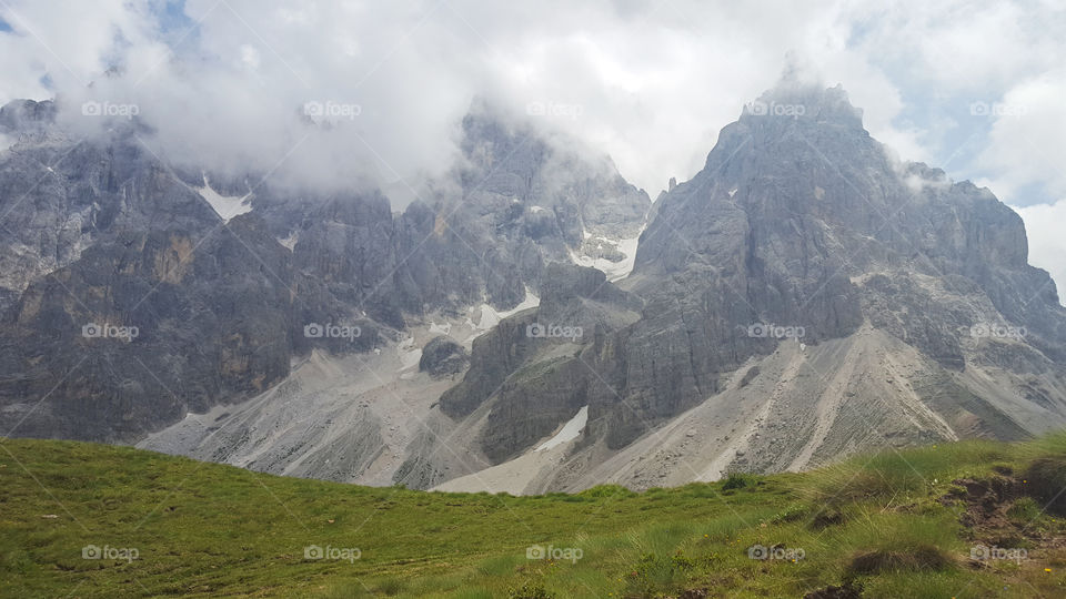 Hiking trail in the mountains, high mountain peaks and clouds 