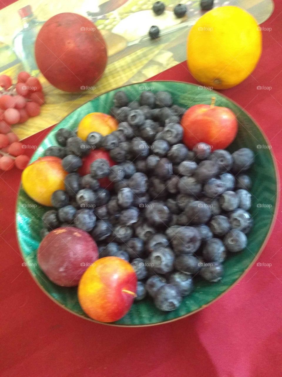 and this picture is blueberries good baby peaches and lemon also a pomegranate taking on my dining table and as you can see I like working with bright colors