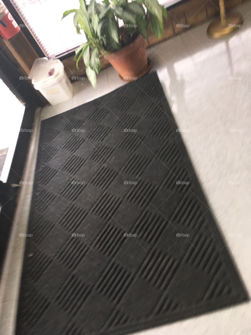 Not to colorful floor mat full of line and triangles which makes a diamond pattern.