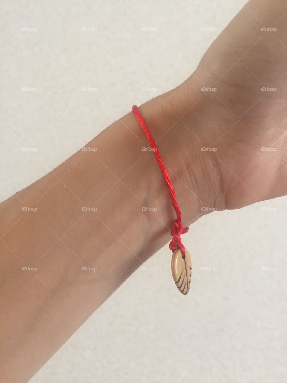 Handmade red fiber bracelet with a leaf