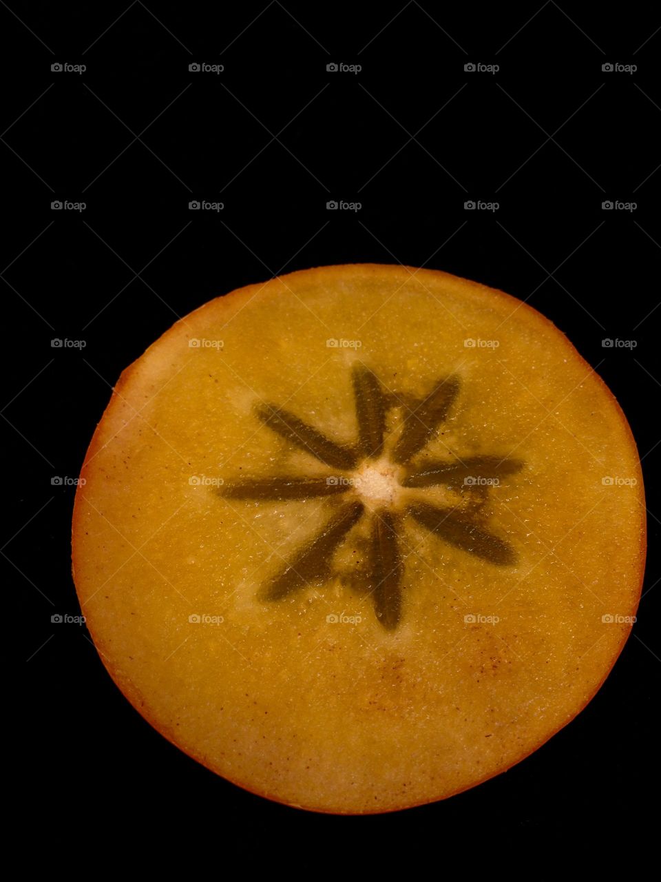 Persimmon slice close up isolated on black