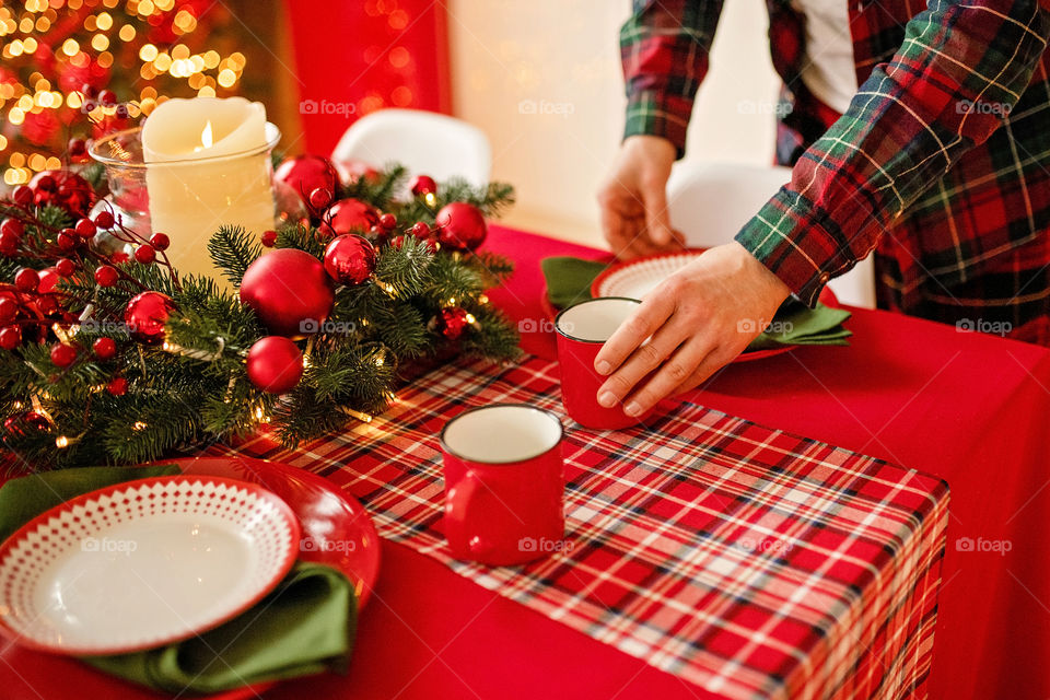 man sets a beautiful decorated winter table for a festive dinner.  Merry Christmas and Happy New Year.