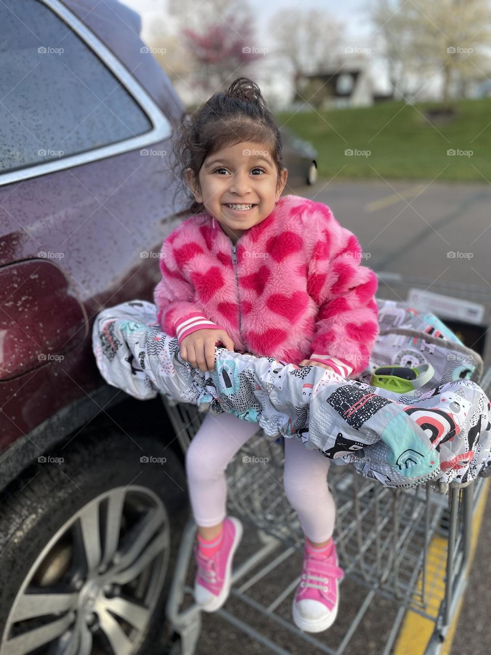 Toddler going grocery shopping with Mommy, smiling for the camera, pretty in pink, little girl excited about grocery shopping 