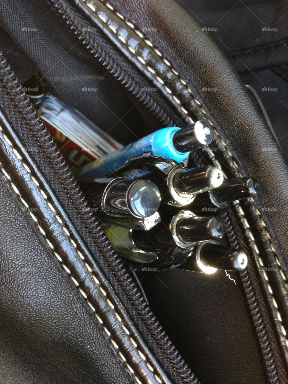 Open zipper purse with lots of pens and cards inside