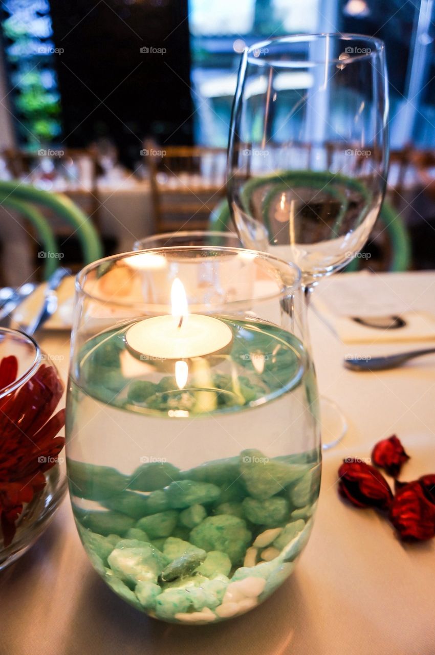 Floating candle with blue stones in glass
