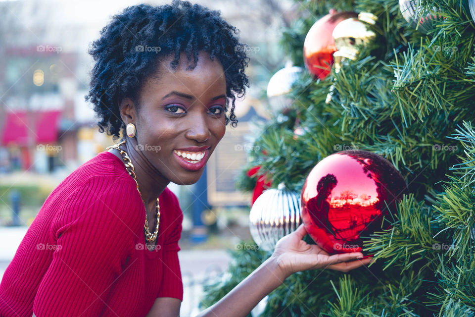 Smiling african woman holding christmas bauble