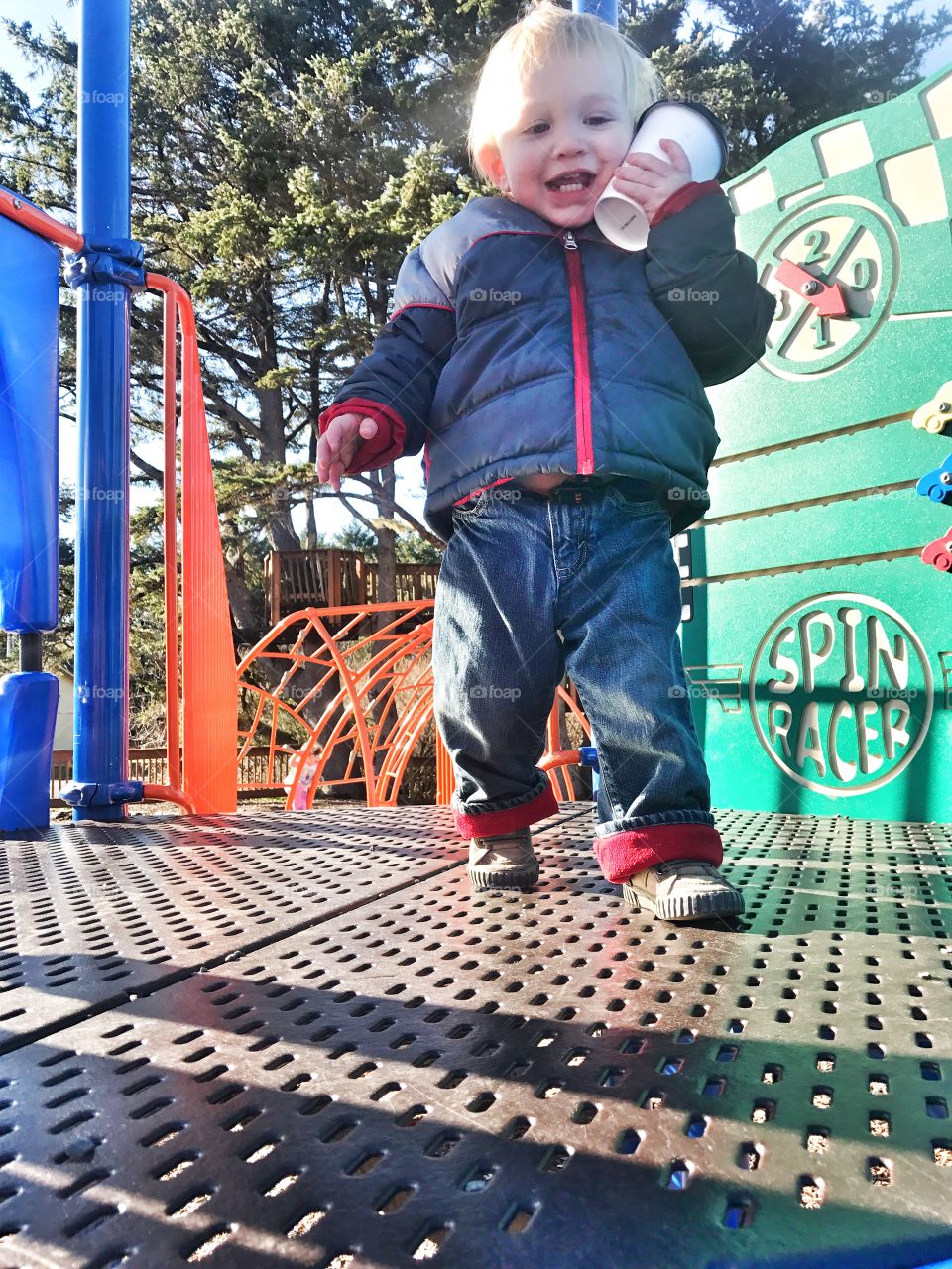 Cute little boy holding drink at playground