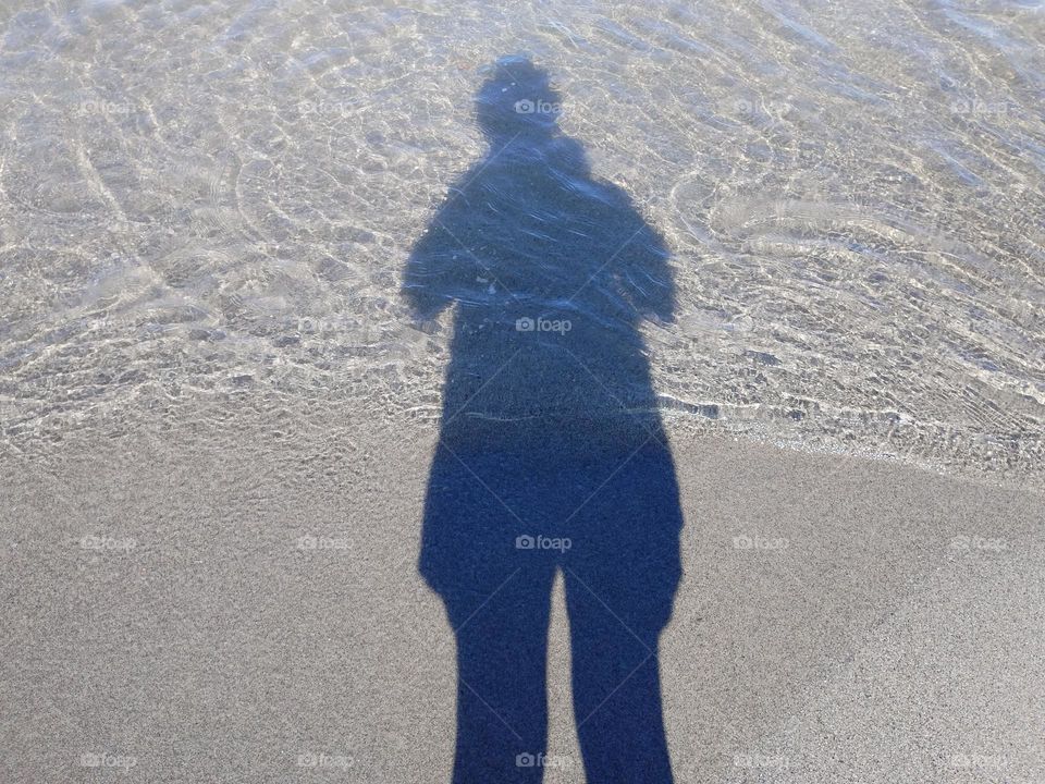 Shadow in the sand and sea water
