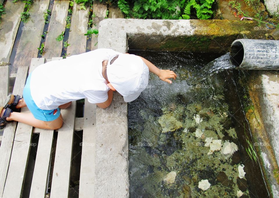 A kid playing on an old spring fountain