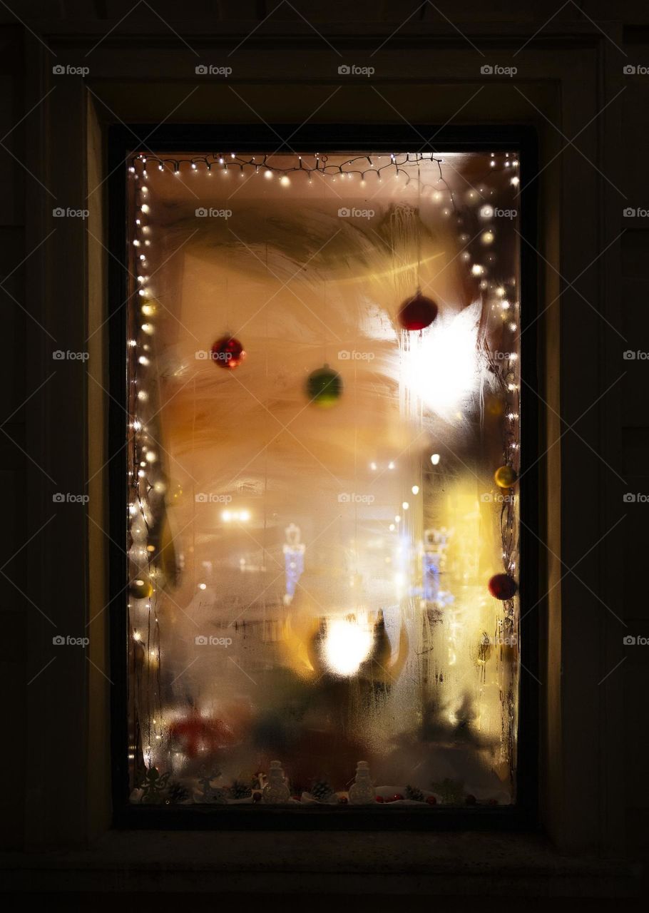 Abstract, steamy window with Christmas decoration. 