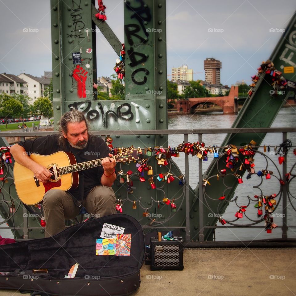 Soundtrack of the bridge. Musician, playing his music above the Eiserner Steg, Frankfurt