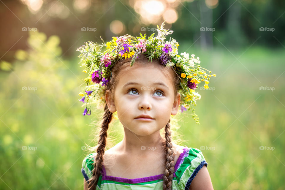 Little girl with flowers in summer 