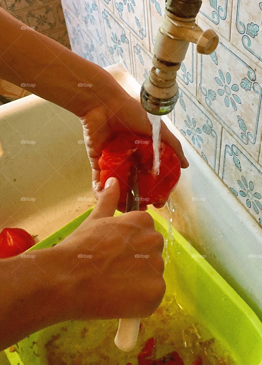 Cutting out the damaged part of a tomato while working on the farm