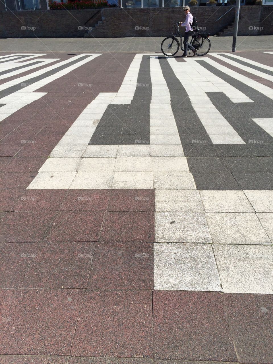 Man pushing his bike on pedestrian boulevard 