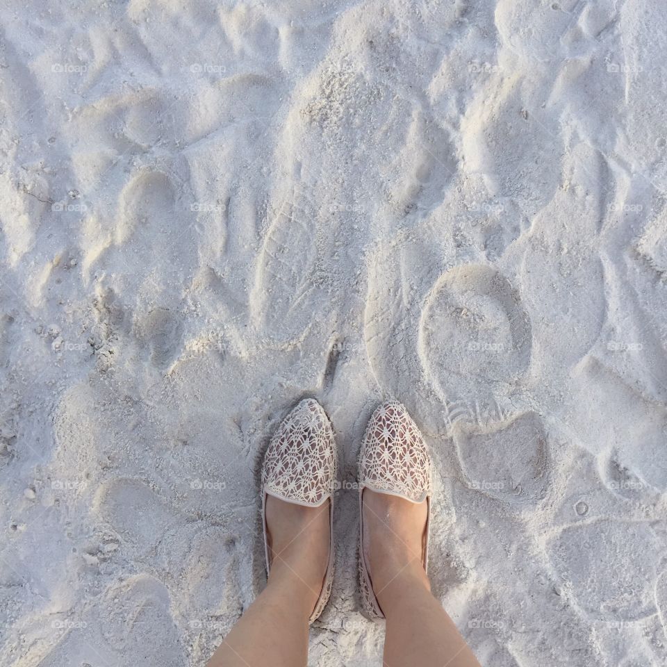 Selfie of woman feet wearing flip flops on a beach, vintage process